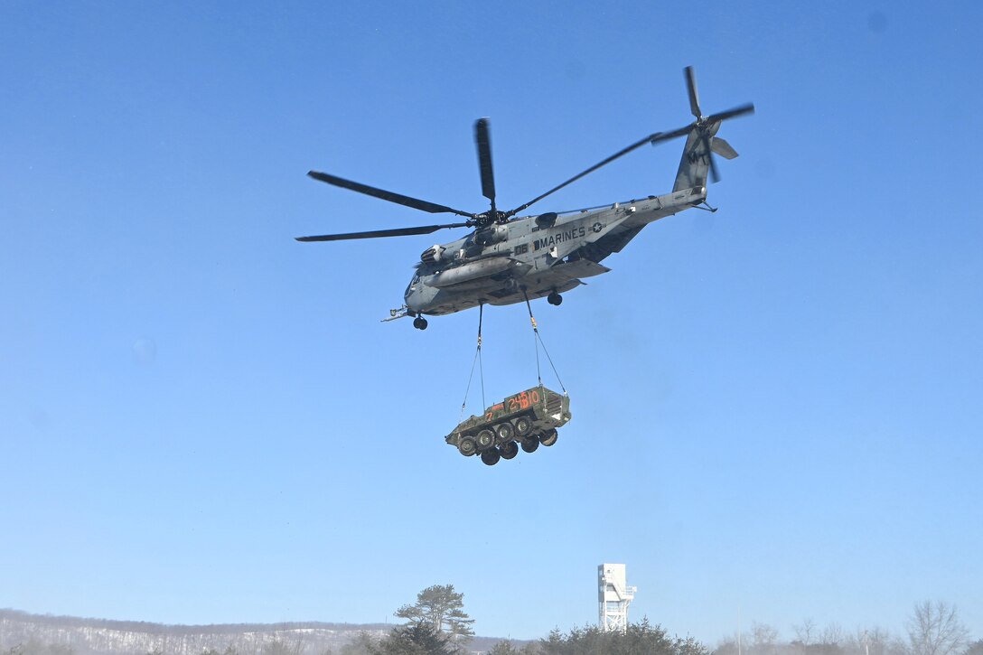 A Marine CH-53 Super Stallion helicopter from Marine Heavy Helicopter Squadron 772 out of Joint Base Maguire-Dix-Lakehurst, New Jersey, air-lifts a decommissioned Army Stryker vehicle to Fort Indiantown Gap’s impact area Jan. 22, 2025. A team of Air Force sling-load specialists from the 621st Contingency Response Group sling-loaded the Stryker to the helicopter. (Pennsylvania National Guard photo by Brad Rhen)