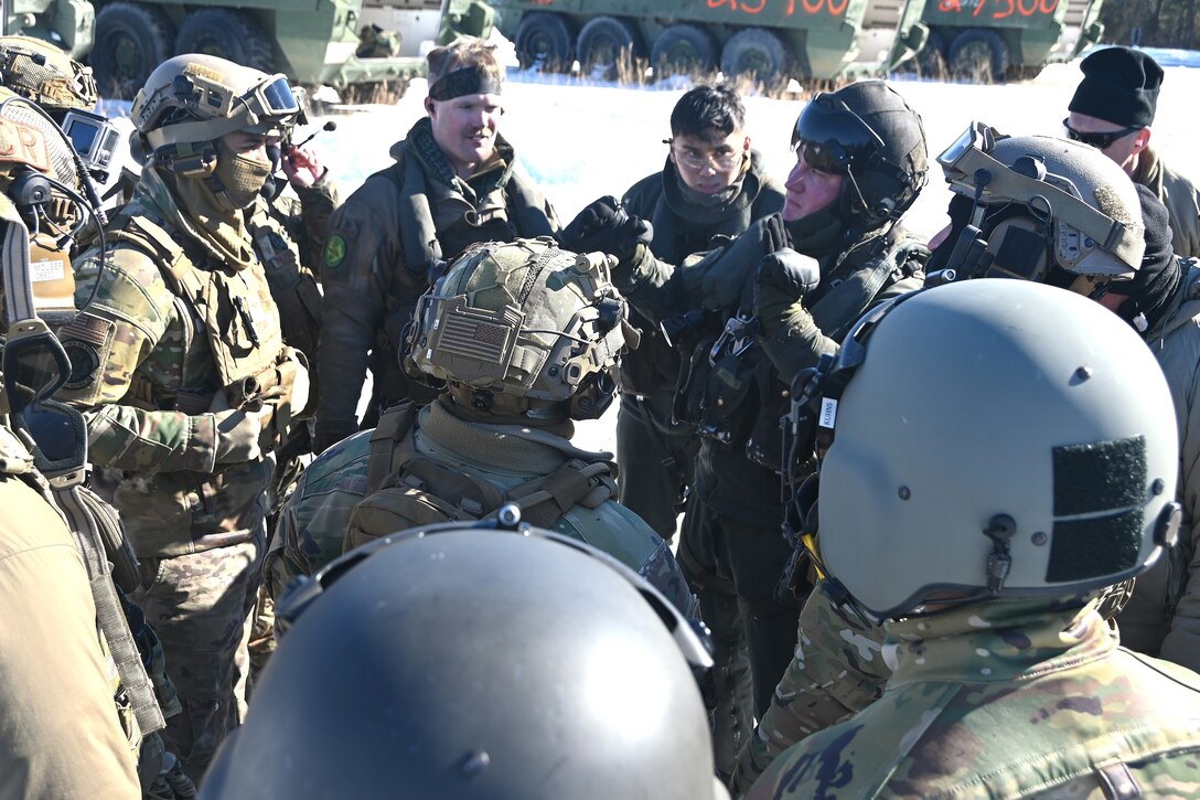 A Marine CH-53 Super Stallion helicopter pilot from Marine Heavy Helicopter Squadron 772 out of Joint Base Maguire-Dix-Lakehurst, New Jersey, gives instructions to Air Force sling-load specialists from the 621st Contingency Response Group and Soldiers from the Fort Indiantown Gap Training Center prior to an operation to air-lift eight decommissioned Army Stryker vehicles to Fort Indiantown Gap’s impact area Jan. 22, 2025. (Pennsylvania National Guard photo by Brad Rhen)