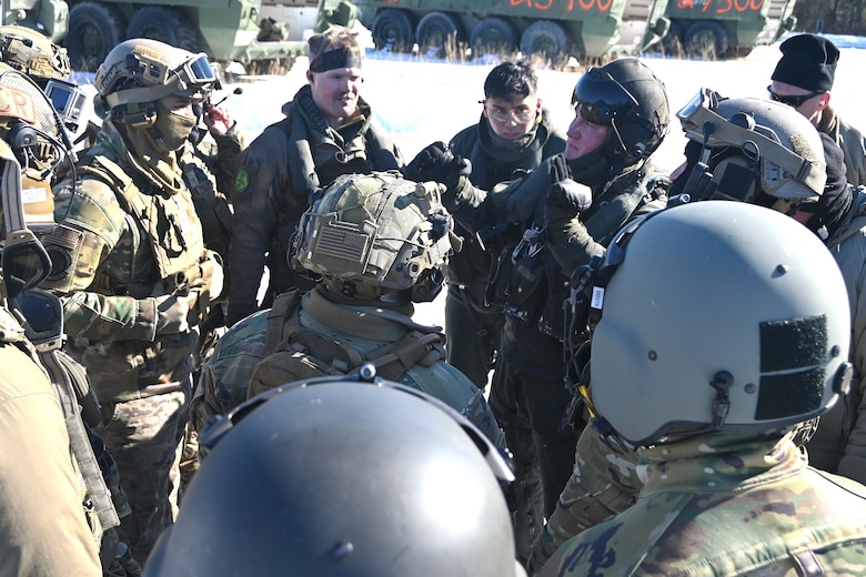 A Marine CH-53 Super Stallion helicopter pilot from Marine Heavy Helicopter Squadron 772 out of Joint Base Maguire-Dix-Lakehurst, New Jersey, gives instructions to Air Force sling-load specialists from the 621st Contingency Response Group and Soldiers from the Fort Indiantown Gap Training Center prior to an operation to air-lift eight decommissioned Army Stryker vehicles to Fort Indiantown Gap’s impact area Jan. 22, 2025. (Pennsylvania National Guard photo by Brad Rhen)