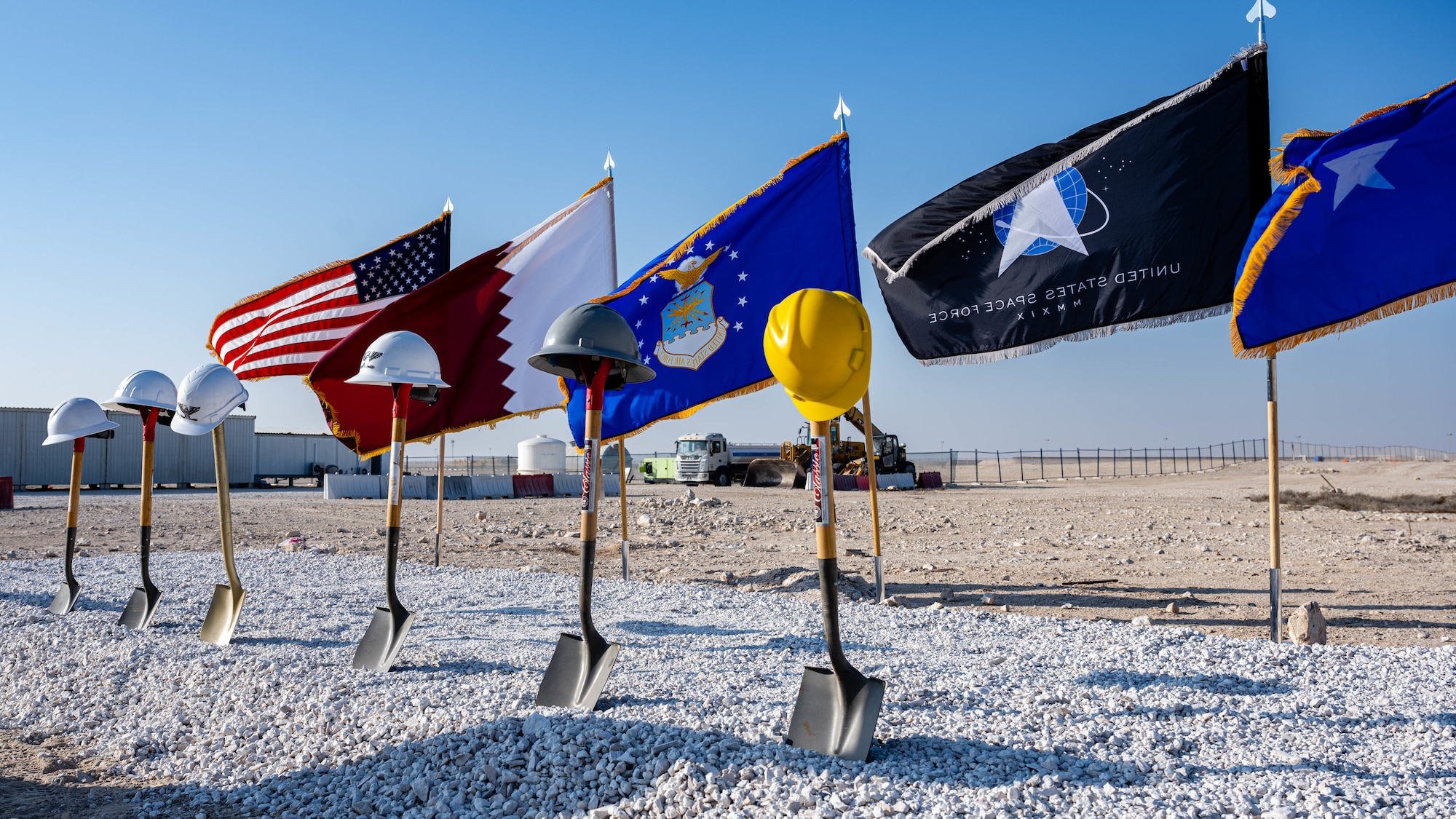 Flags and shovels are displayed at a groundbreaking ceremony.