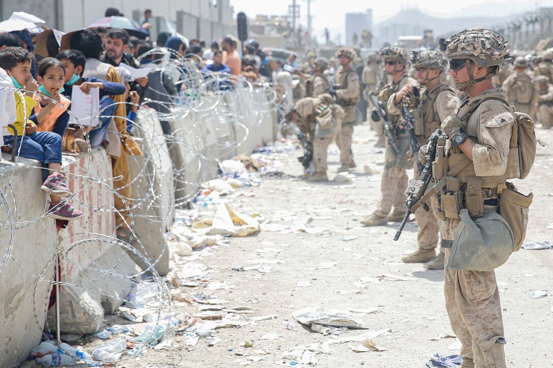 U.S. Marines with Special Purpose Marine Air-Ground Task Force - Crisis Response - Central Command, provide assistance during an evacuation at Hamid Karzai International Airport, Kabul, Afghanistan, Aug. 20. U.S. service members are assisting the Department of State with an orderly drawdown of designated personnel in Afghanistan.