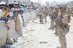 U.S. Marines with Special Purpose Marine Air-Ground Task Force - Crisis Response - Central Command, provide assistance during an evacuation at Hamid Karzai International Airport, Kabul, Afghanistan, Aug. 20. U.S. service members are assisting the Department of State with an orderly drawdown of designated personnel in Afghanistan.