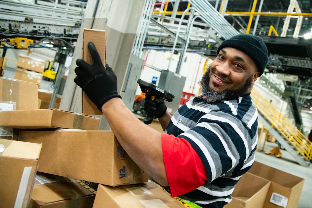 Kerry Conyers, distribution process worker, Defense Logistics Agency Distribution Susquehanna, Pennsylvania, scans incoming packages at the Eastern Distribution Center Jan. 23.