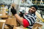 Kerry Conyers, distribution process worker, Defense Logistics Agency Distribution Susquehanna, Pennsylvania, scans incoming packages at the Eastern Distribution Center Jan. 23.