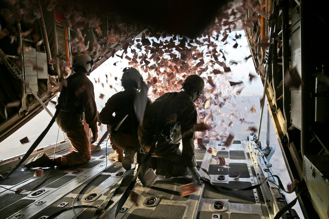 U.S. Marine Corps Cpl. Jameson Dudley, left, crew master with Marine Aerial Refueler Transport Squadron 252 (VMGR-252), and U.S. Army Sgt. Nijoku Odom, right, intelligence analyst with 303rd psychological operations company (303rd POCO), throw leaflets from a KC-130 Super Hercules over southern Afghanistan.