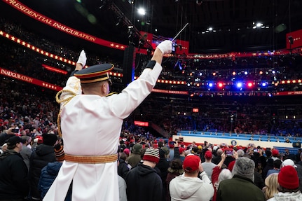 Band conductor leads ensemble over crowd of attendees