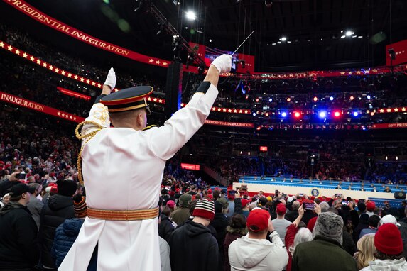 Band conductor leads ensemble over crowd of attendees