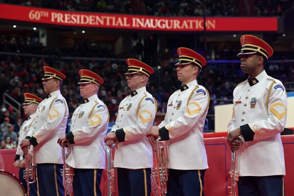 Band members stand at the ready with their instruments resting at their waist in front of them