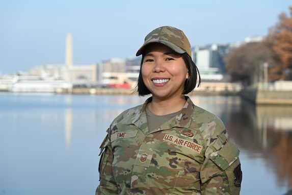 Service member standing for portrait with monument in the background