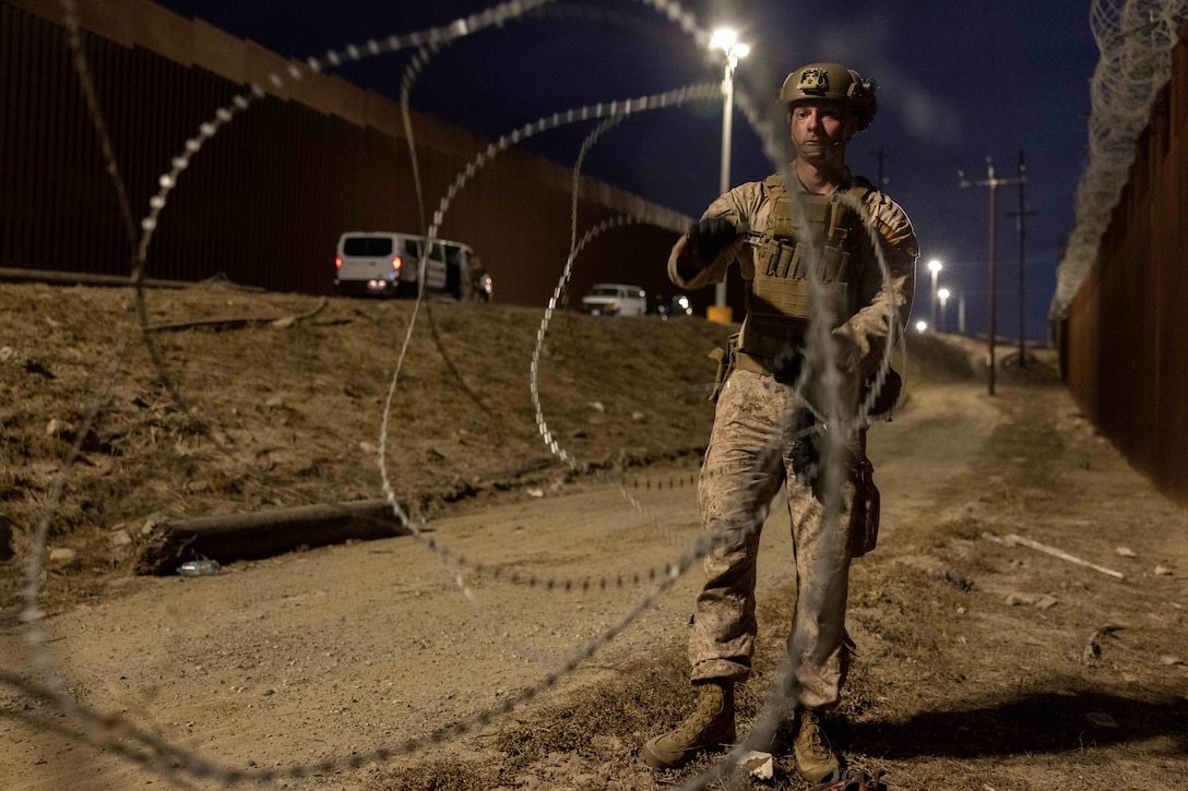 A man wearing a uniform unravels wire.