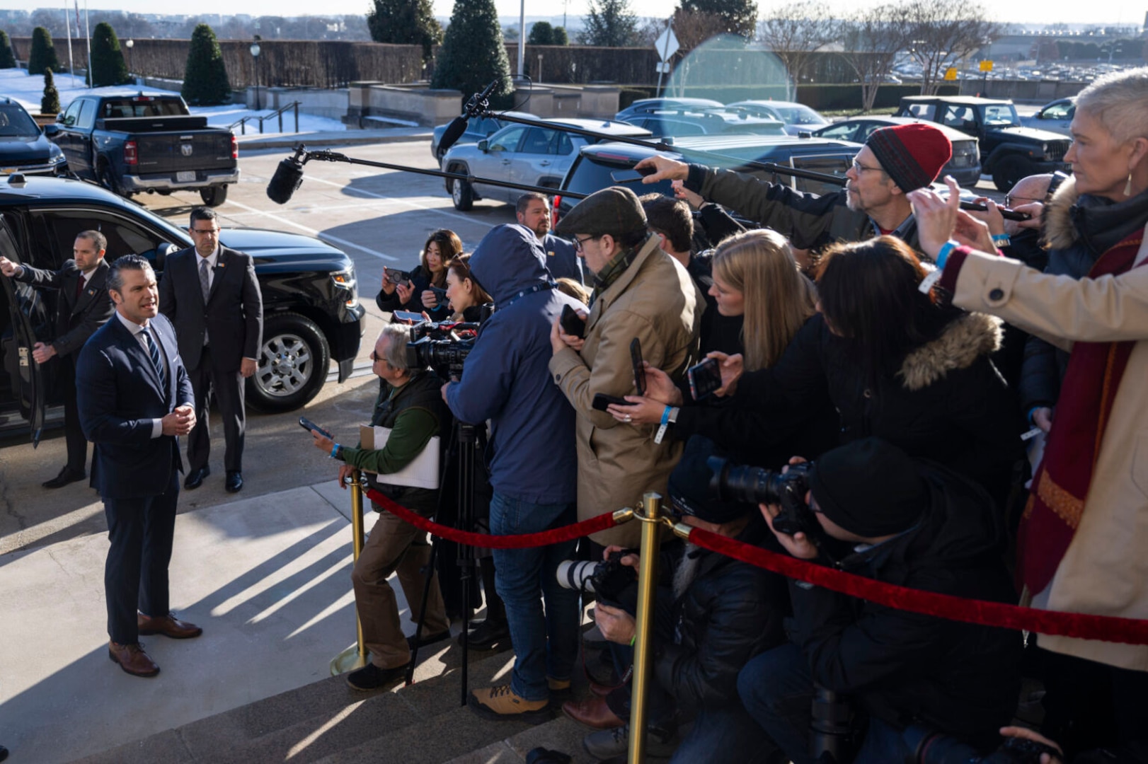 A man wearing business attire speaks to the press on the steps of the Pentagon.