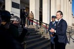 A man wearing business attire speaks to the press on the steps of the Pentagon.