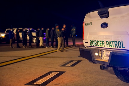 Agents guide illegal aliens to board an aircraft.