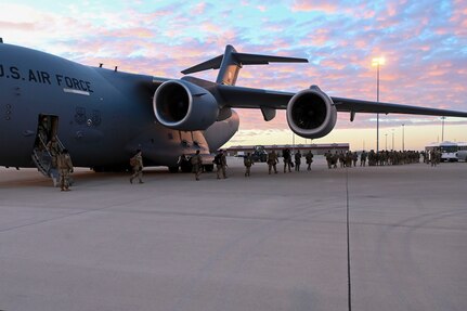 Soldiers exit an aircraft.