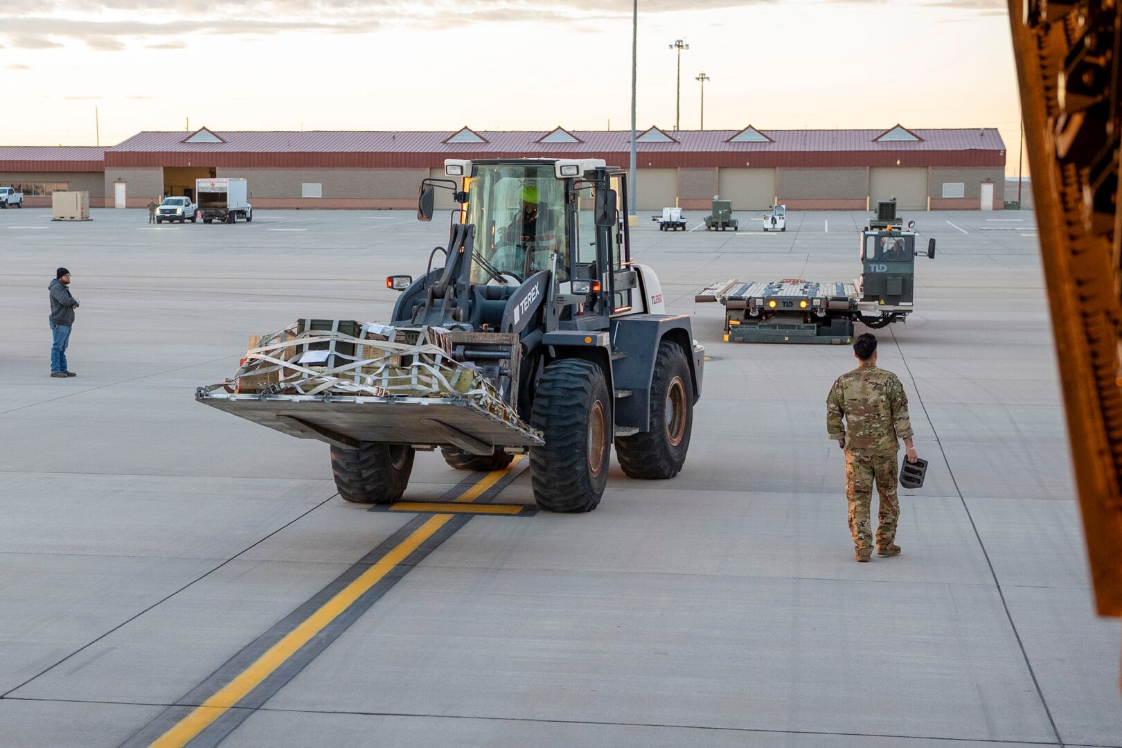 A forklift removes a pallet of luggage and equipment from an aircraft.