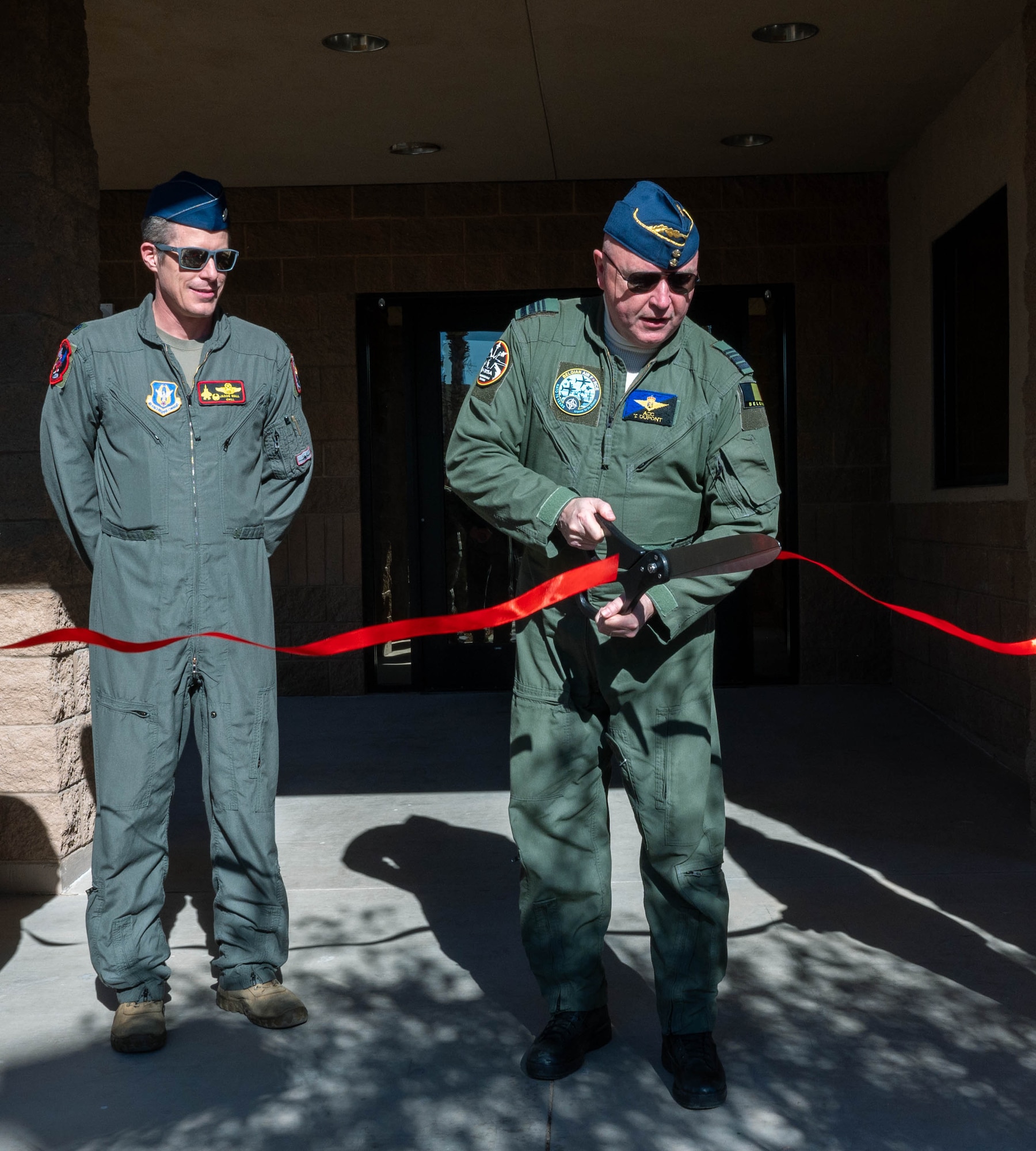 Belgian Air and Space Component Maj. Gen. Thierry Dupont (center right), BASC commander, and Lt. Col. Jason Wall (center left), 312th Fighter Squadron commander, participate in a ribbon cutting ceremony for the 312th FS’s new building, Jan. 16, 2025, at Luke Air Force Base, Arizona.