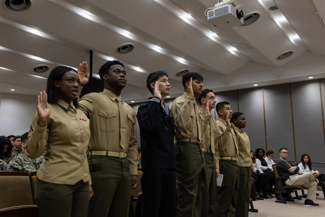 U.S. Marines and a Sailor stationed at Marine Corps Air Station Iwakuni recite the oath of allegiance during a naturalization ceremony at MCAS Iwakuni, Japan, Jan. 24, 2025. The naturalization ceremony was held to acknowledge MCAS Iwakuni service members becoming citizens of the United States. The ceremony included service members from Haiti, South Korea, Ukraine, Mexico, and Fiji. (U.S. Marine Corps photo by Cpl. Colin Thibault)