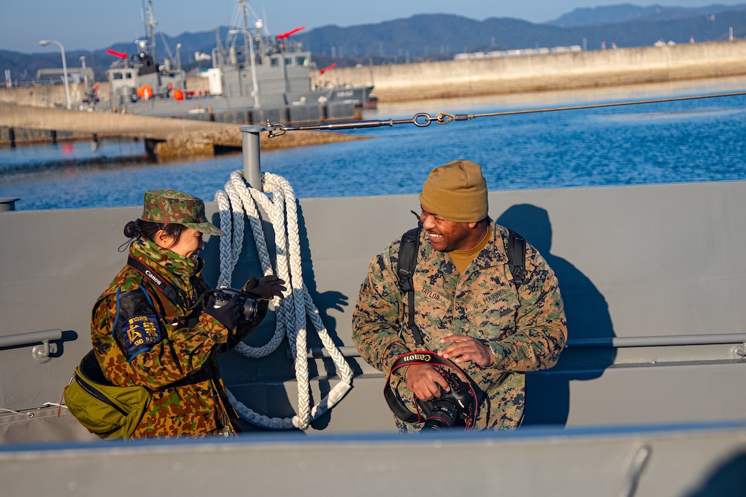 U.S. Marine Corps Lance Cpl. Micah Taylor, a combat videographer with Headquarters and Headquarters Squadron, Marine Corps Air Station Iwakuni, and a native of Florida, speaks with a Japan Ground Self-Defense Force member from the 13th Brigade, Middle Army, aboard a Japan Maritime Self-Defense Force transport vessel during Exercise Nankai Rescue at MCAS Iwakuni, Japan, Jan. 16, 2025. Exercise Nankai Rescue 2024 is a full-scale exercise focused on enhancing bilateral coordination between the U.S. and Japan in support of humanitarian and disaster relief efforts. (U.S. Marine Corps photo by Lance Cpl. Rylan Adcock)