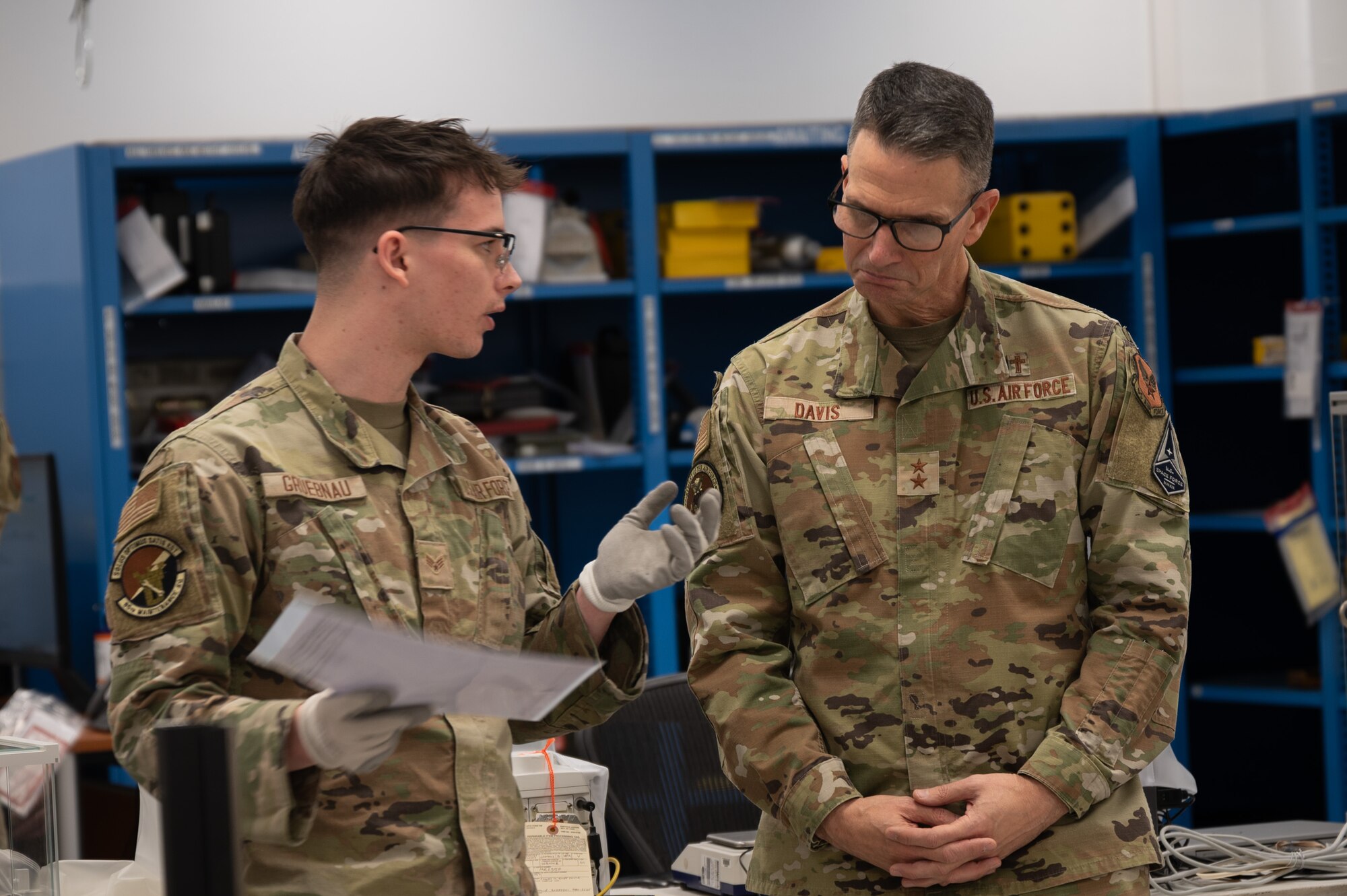 U.S. Air Force Senior Airman Matthew Gruebnau, 86th Maintenance Squadron physical/dimensional technician, explains his daily duties to Maj. Gen. Trent C. Davis, Headquarters U.S. Air Force chief of chaplains, at Ramstein Air Base, Germany, Jan. 24, 2025.