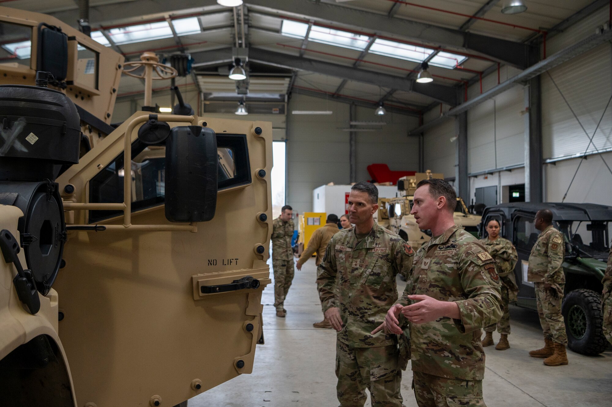 U.S. Air Force Tech. Sgt. Matthew Oiler, right, 435th Security Forces Squadron administration and assessments section chief, describes the capabilities of an OshKosh Joint Light Tactical Vehicle to U.S. Air Force Maj. Gen. Trent C. Davis, left, Headquarters U.S. Air Force chief of chaplains, at Ramstein Air Base, Germany, Jan. 24, 2025.