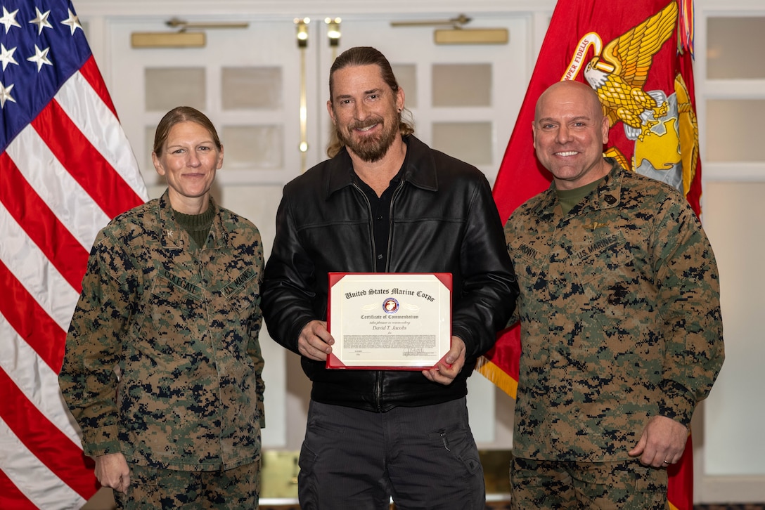 David Jacobs, an IT specialist with Management Information Systems, Marine Corps Community Services, poses with U.S. Marine Corps Col. Jenny Colegate, commanding officer of Marine Corps Base Quantico, left, and Sgt. Maj. Michael R. Brown, sergeant major of MCBQ, during the Civilian Quarterly Awards at The Clubs at Quantico, MCBQ, Virginia, January 23, 2025. Jacobs was recognized with the Senior Non-Appropriated Fund Personnel Civilian Employee of the Quarter for work done in the 4th quarter of 2024. (U.S. Marine Corps photo by Lance Cpl. David Brandes)