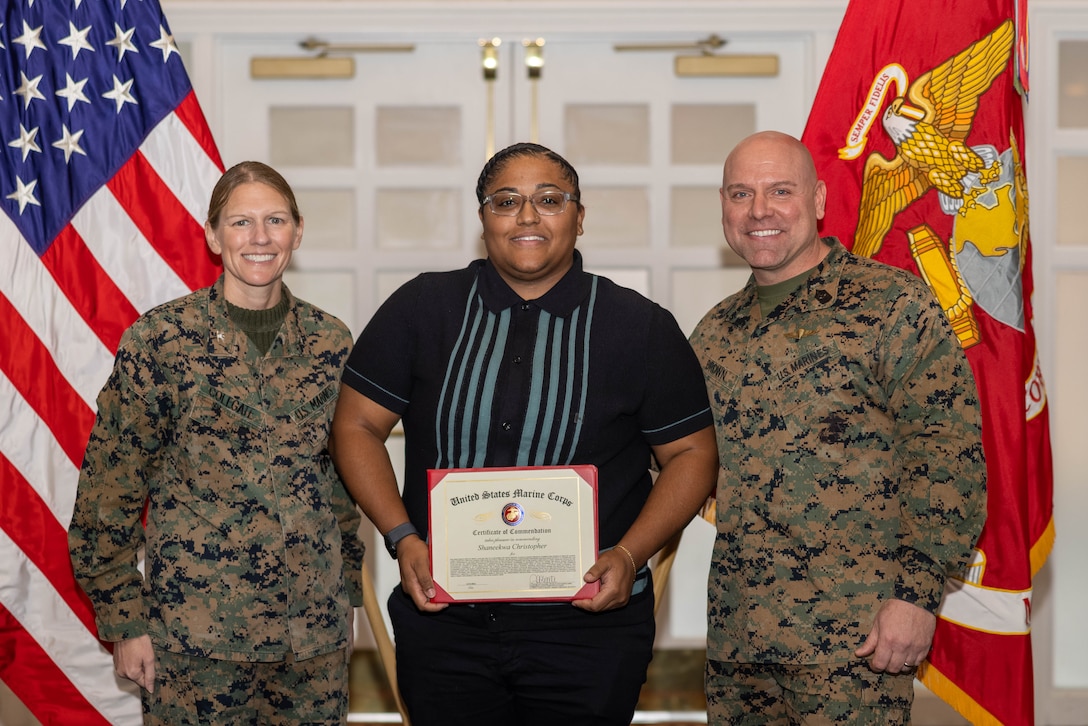 Shaneekwa Christopher, a single marine program coordinator, Semper Fit Branch, Marine Corps Community Services, poses with U.S. Marine Corps Col. Jenny Colegate, commanding officer of Marine Corps Base Quantico, left, and Sgt. Maj. Michael R. Brown, sergeant major of MCBQ, during the Civilian Quarterly Awards at The Clubs at Quantico, MCBQ, Virginia, January 23, 2025. Christopher was recognized with the Junior Non-Appropriated Fund Personnel Civilian Employee of the Year for work done in 2024. (U.S. Marine Corps photo by Lance Cpl. David Brandes)