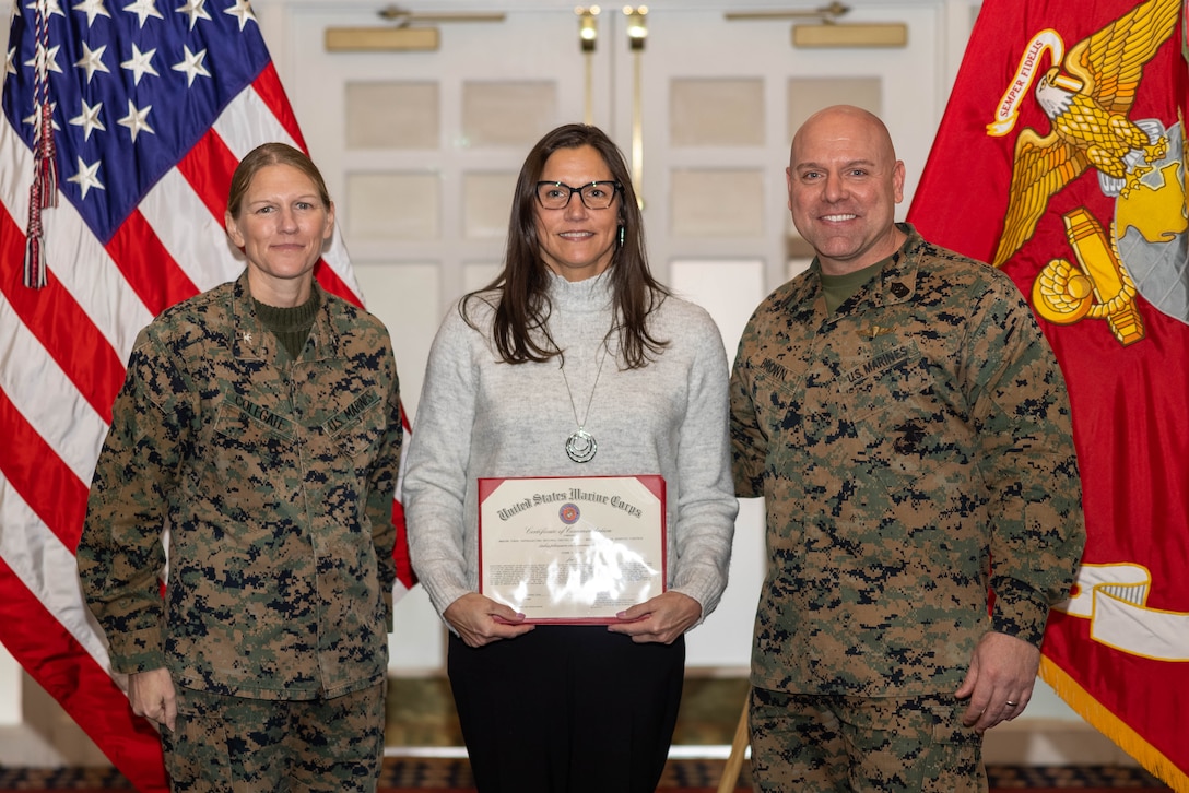Diane D. Wyss, an investigation and compliance specialist with The Office of the Command Inspector General, poses with U.S. Marine Corps Col. Jenny Colegate, commanding officer of Marine Corps Base Quantico, left, and Sgt. Maj. Michael R. Brown, sergeant major of MCBQ, during the Civilian Quarterly Awards at The Clubs at Quantico, MCBQ, Virginia, January 23, 2025. Wyss was recognized as the Senior Appropriated Fund Personnel Civilian Employee of the Year for work done in 2024. (U.S. Marine Corps photo by Lance Cpl. David Brandes)