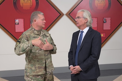 Two men stand face to face talking