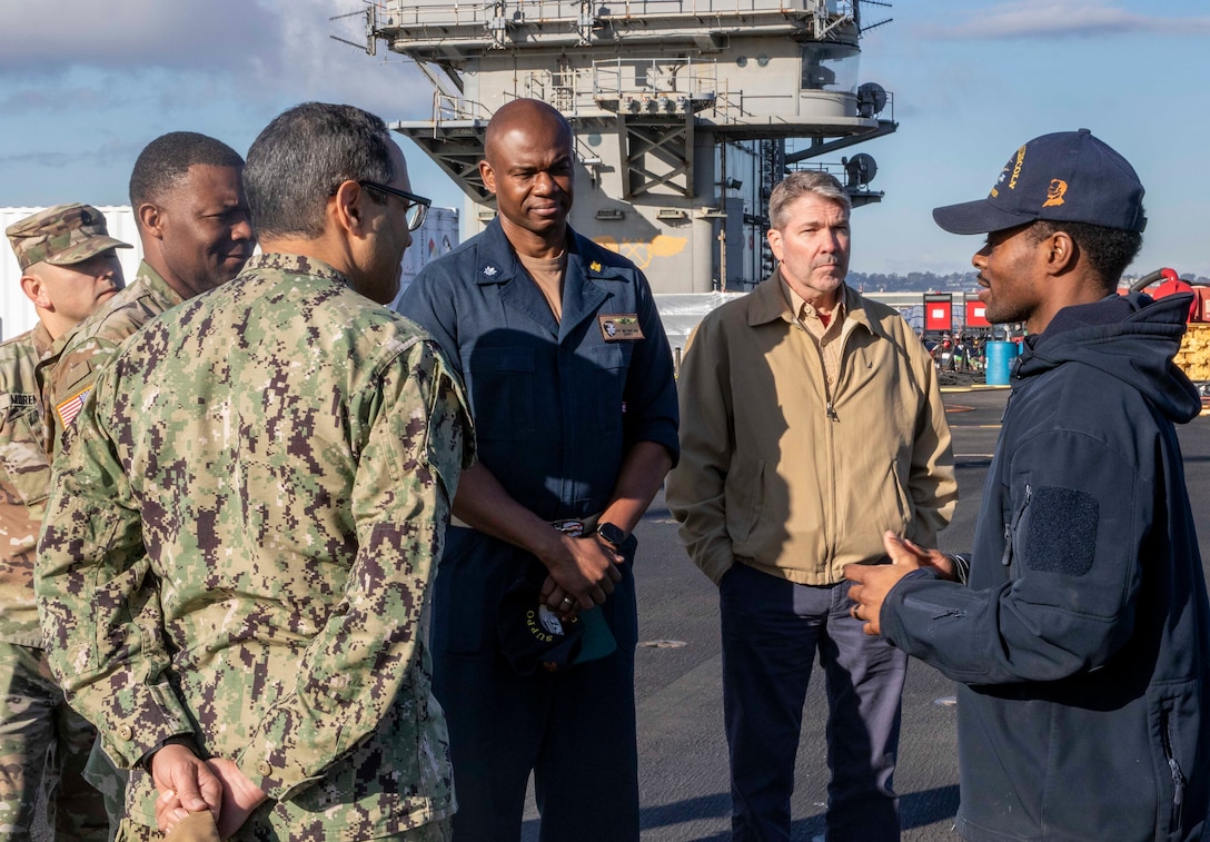 Navy sailor briefs distinguished visitors/.