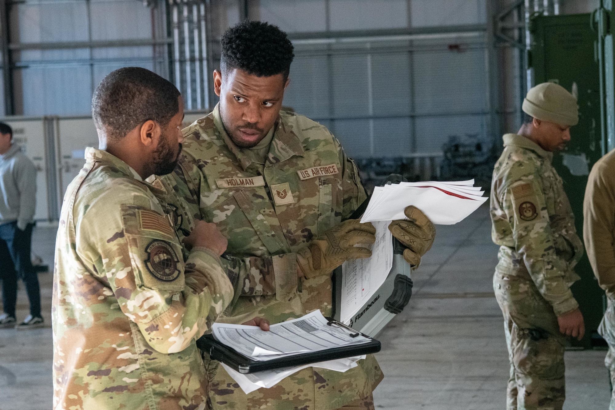 Airmen speak with each other during a joint cargo inspection