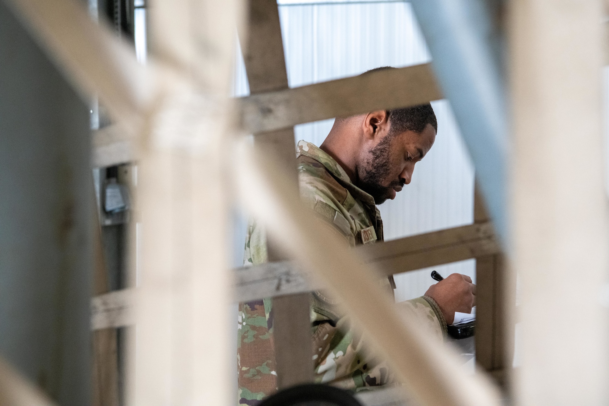An Airman  writes down cargo measurements as part of a joint cargo inspection