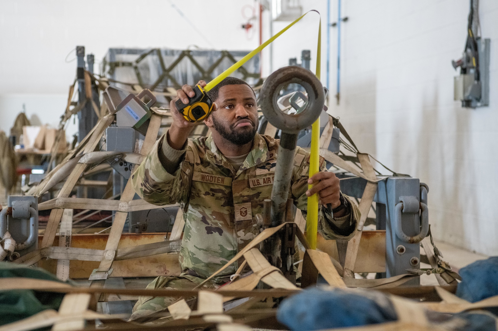 An Airman measures cargo as part of a joint cargo inspection