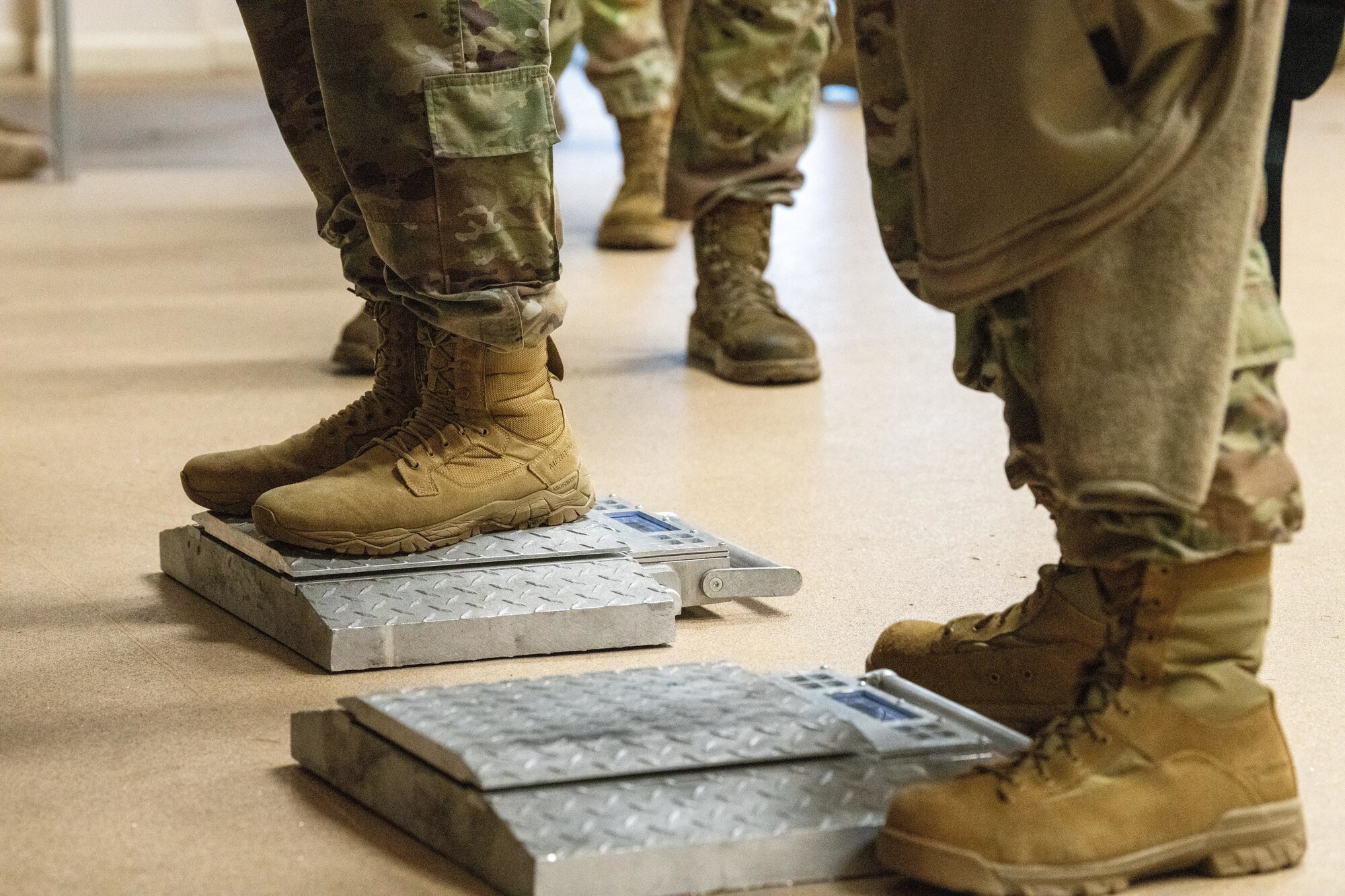 Airmen stand on portable wheel loader scales