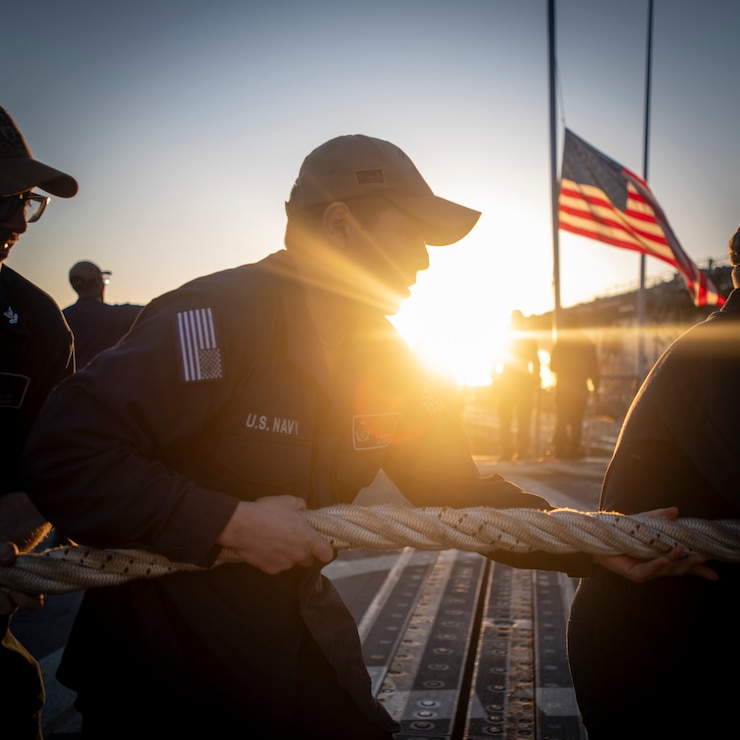 Sailors handle a mooring line on the flight deck of the Arleigh Burke-class guided-missile destroyer USS Sampson (DDG 102) while departing Naval Base San Diego, Jan. 23, 2025.