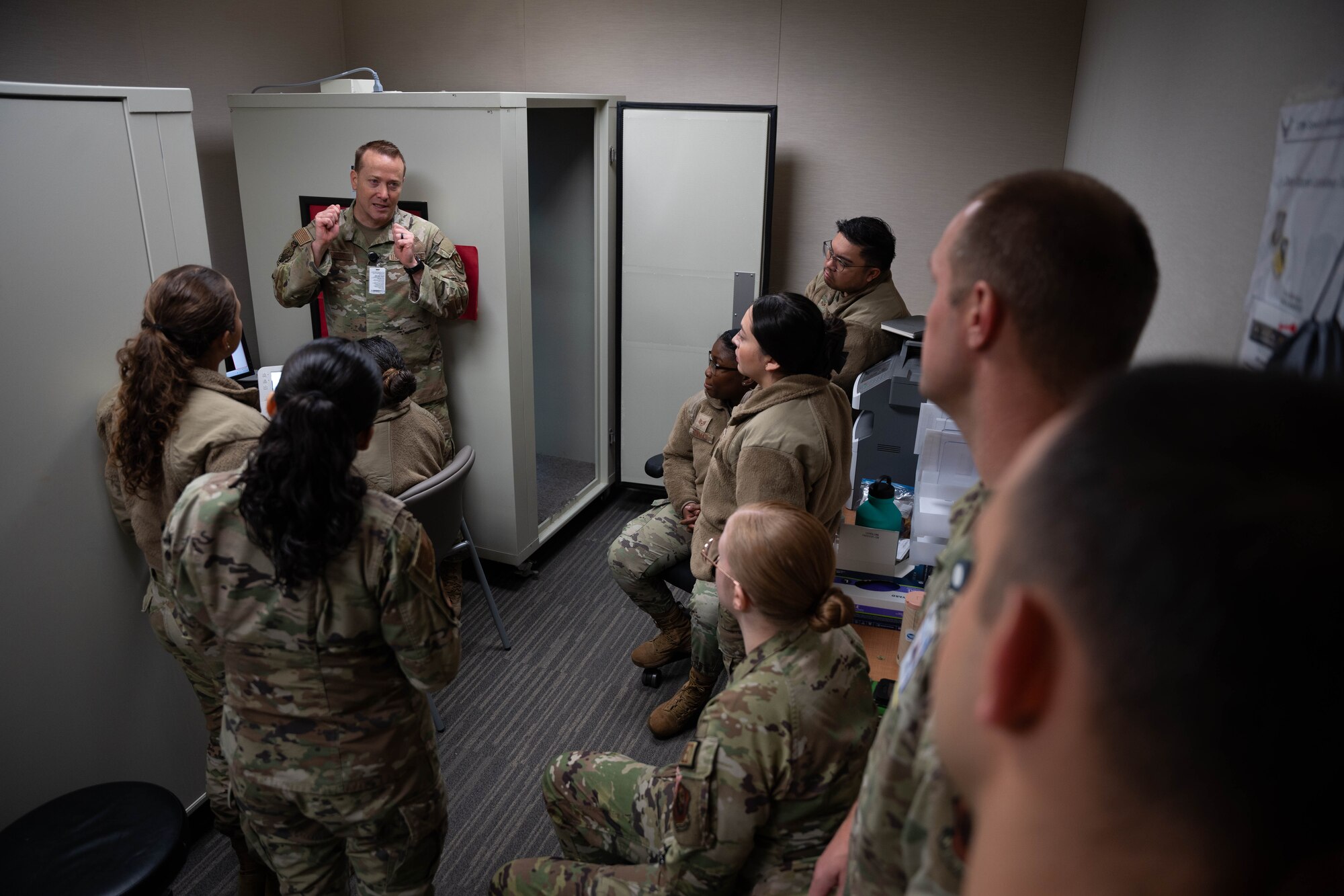 Lt. Col. John Foster, United States Air Force Hearing Conservation Program Manager, introduces tele-audiology equipment to Airmen from the 27th Special Operations Medical Group at Cannon Air Force Base, New Mexico, Dec. 10, 2024. The tele-audiology service utilizes specialized equipment and software to conduct the hearing assessments to establish the same level of care and accuracy as a traditional in-person consultation. (U.S. Air Force photo by Senior Airman Mateo Parra)