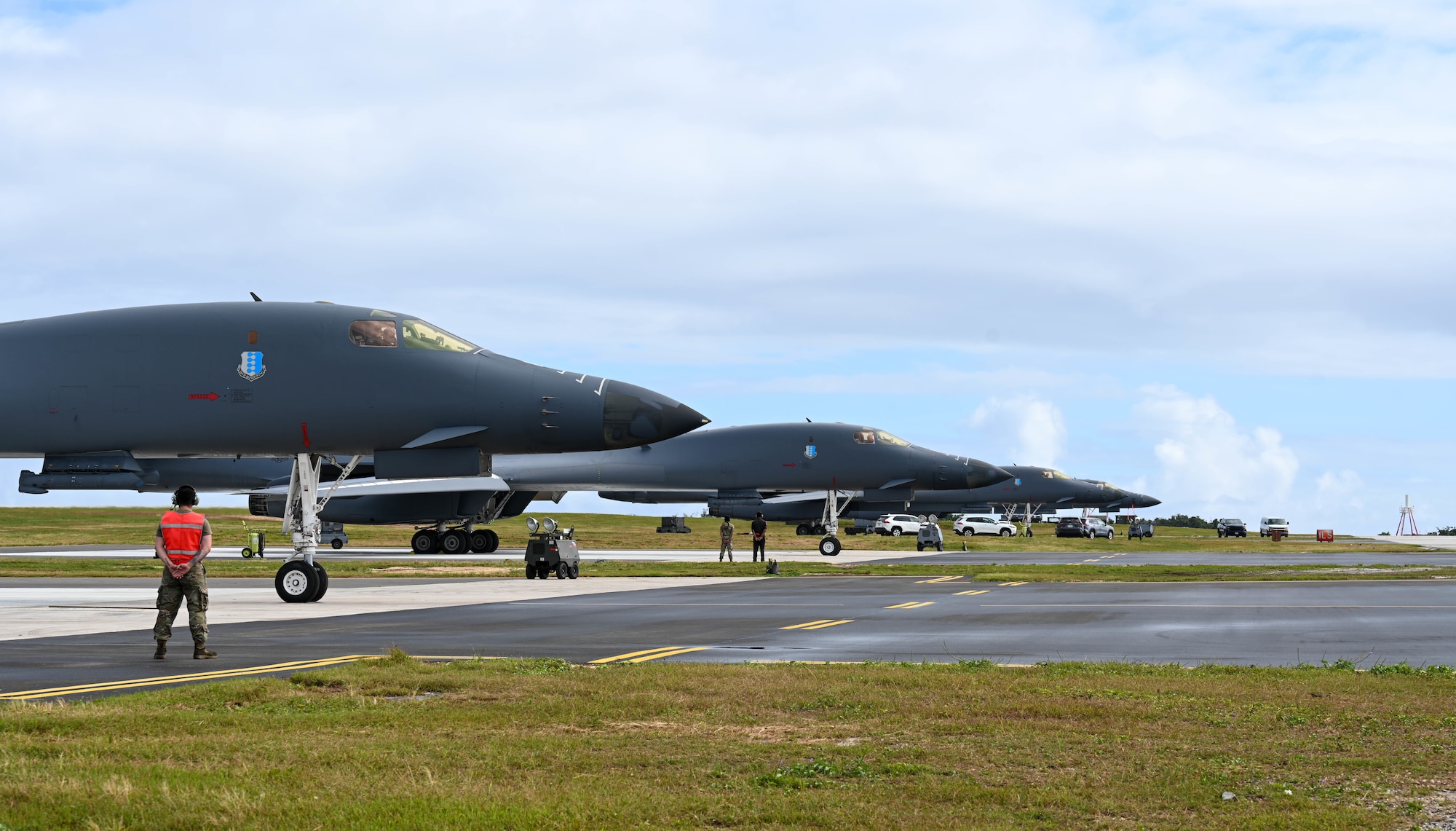 A row of pointy aircraft are lined up next to an open road