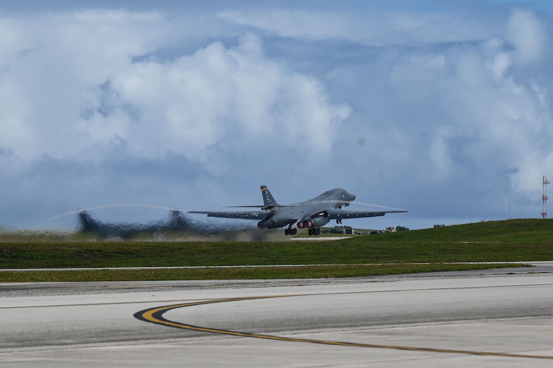 A military jet takes off from a runway.