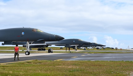 A row of pointy aircraft are lined up next to an open road