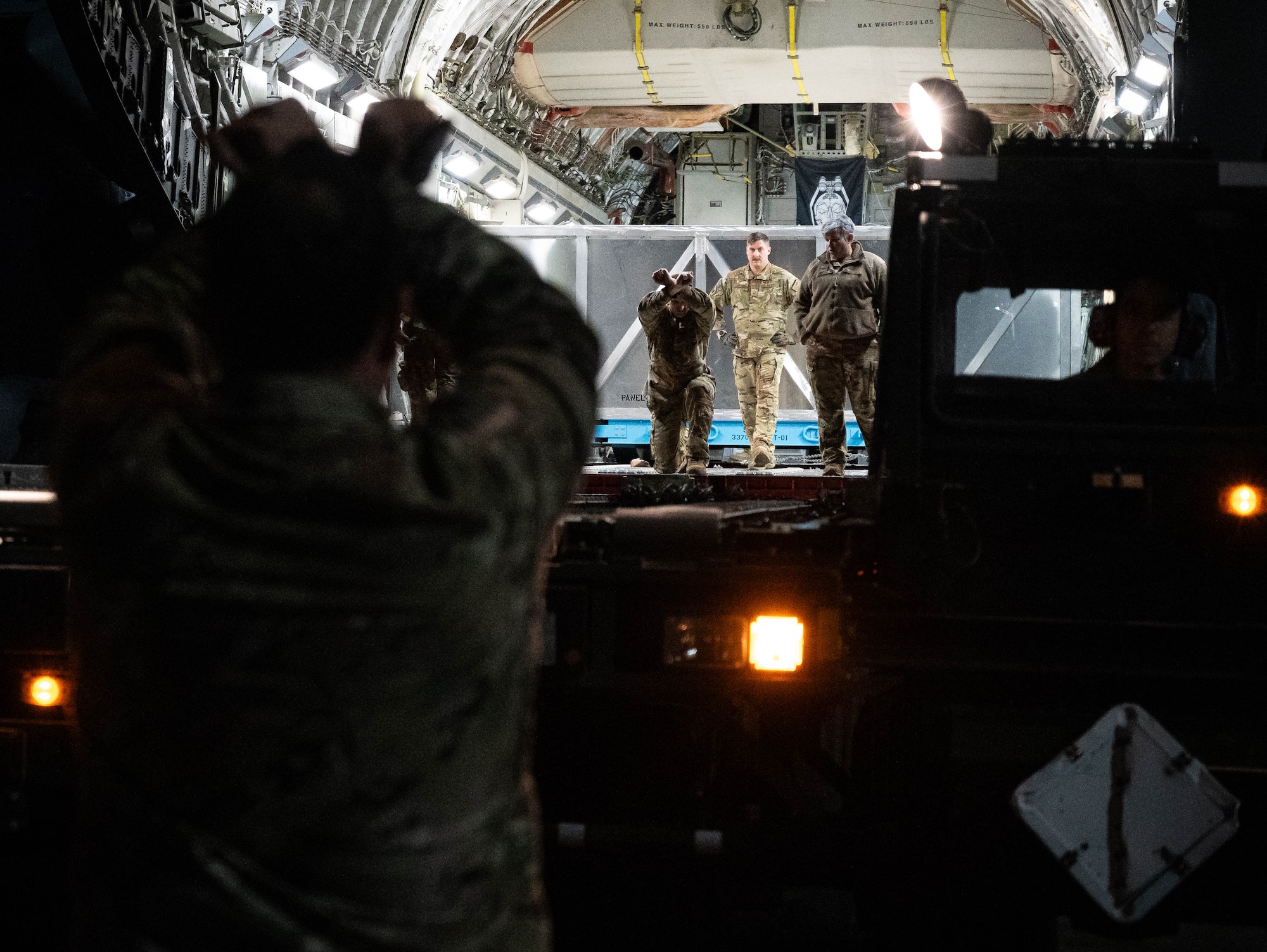 U.S. Airmen assigned to the 86th Maintenance Group, 721st Aircraft Maintenance Squadron, 721st Aerial Port Squadron and the 758th Airlift Squadron prepare to offload a C-130J Super Hercules aircraft wing from a C-17 Globemaster III at Ramstein Air Base, Germany, Jan. 25, 2025. This marked the first ever air transportation of this specific aircraft wing. (U.S. Air Force photo by Senior Airman Jared Lovett)