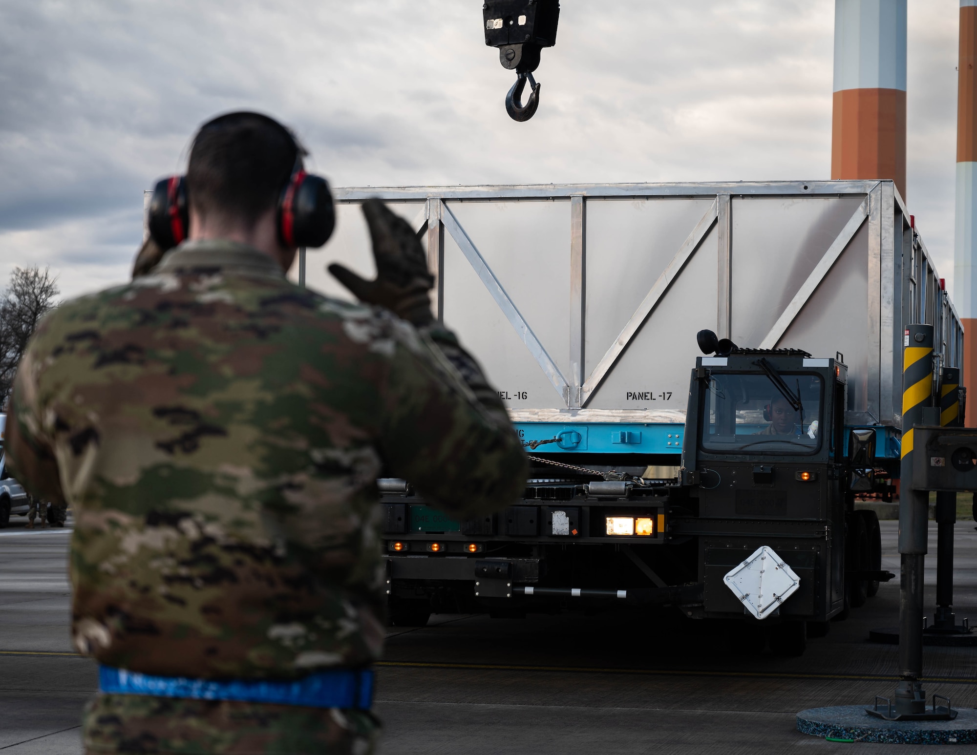 U.S. Air Force Tech. Sgt. Jakob Nance, 721st Aerial Port Squadron noncommissioned officer in charge of ramp operations, spots for U.S. Air Force Staff Sgt. Sydney Willis, 721st APS ramp services supervisor, as she transports a C-130J Super Hercules aircraft wing on a k-loader at Ramstein Air Base, Germany, Jan. 25, 2025. The wing was transported via aircraft from Dobbins Air Reserve Base, Georgia, and marked the first airlift operation of a C-130J Super Hercules aircraft wing. (U.S. Air Force photo by Senior Airman Jared Lovett)