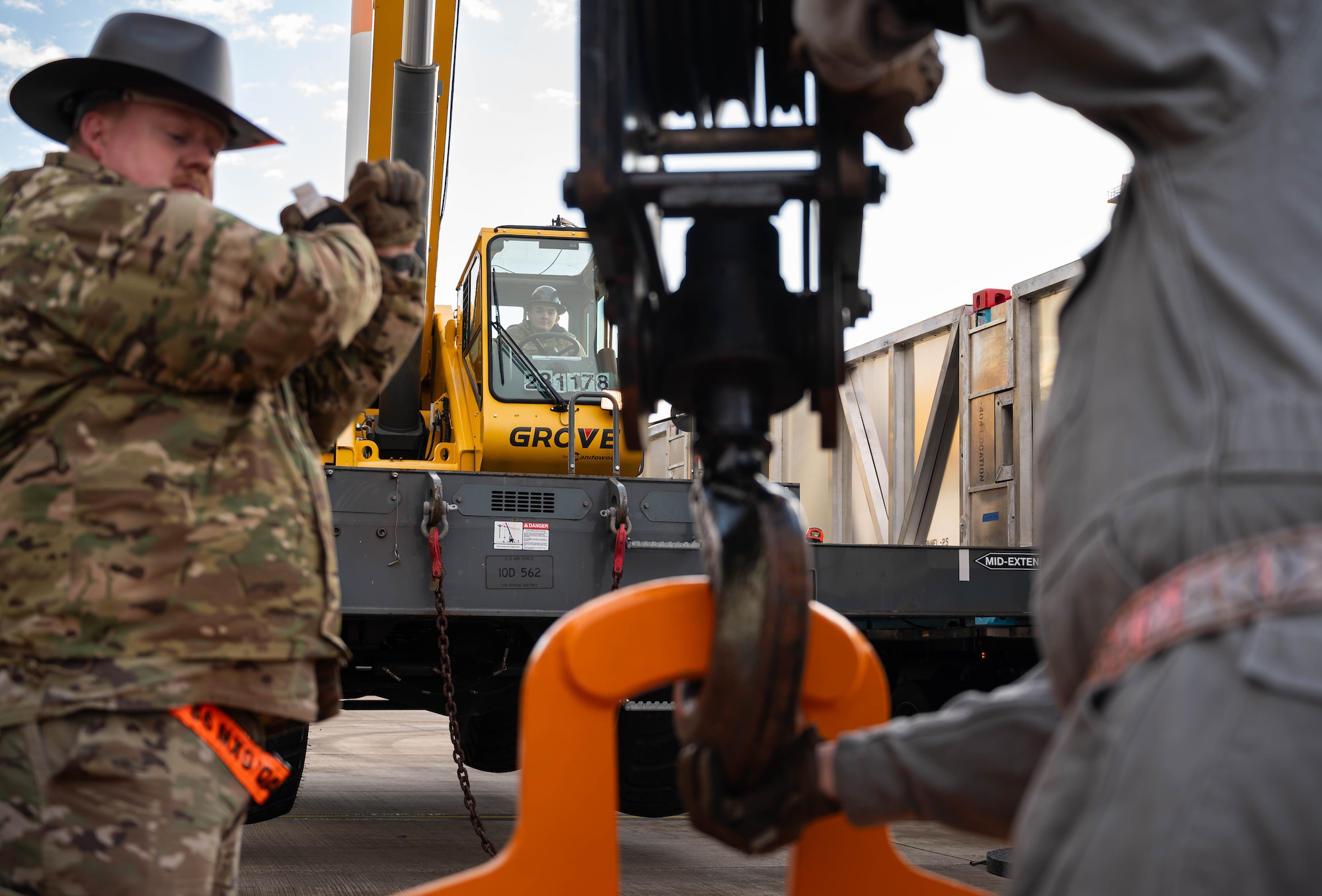 U.S. Air Force Senior Master Sgt. Justin Jordan, 86th Maintenance Group quality assurance superintendent, U.S. Air Force Staff Sgt. Dylan Pohl, 435th Construction and Training Squadron instructor of pavements and equipment contingency training, and Tino Weichel, 86th Maintenance Squadron inspector foreman, fit a spreader bar to pick up a delivery of a C-130J Super Hercules aircraft wing at Ramstein Air Base, Germany, Jan. 25, 2025. This was the first airlift operation of this specific wing which required a custom fixture to make it possible to be transported via aircraft. (U.S. Air Force photo by Senior Airman Jared Lovett)