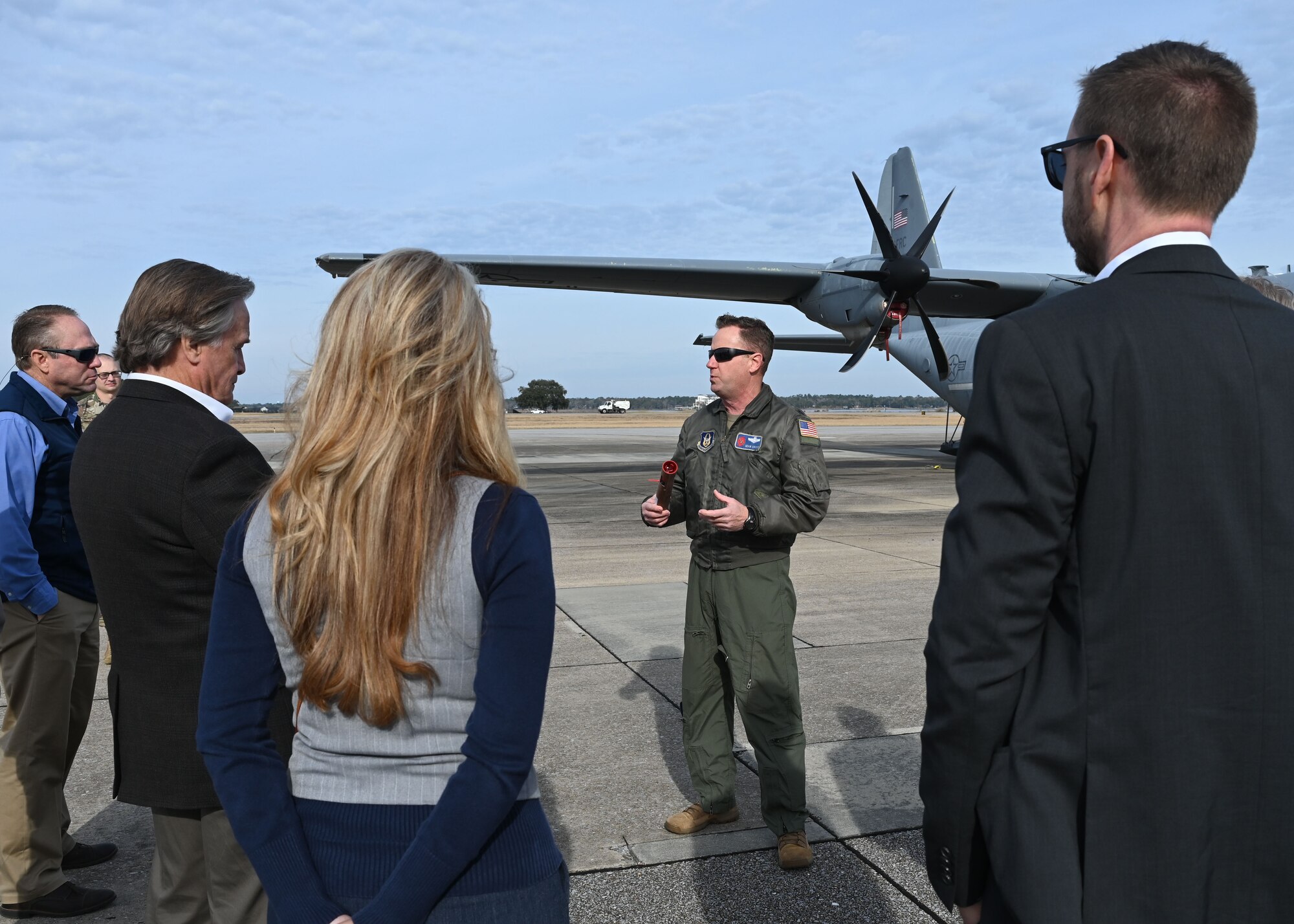 Pilot briefing people in front of aircraft on flightline