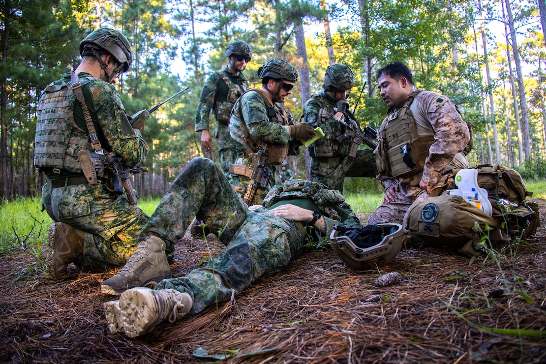 U.S. Navy Hospital Corpsman 3rd Class Joshua Anchanzar, right, with 2nd Medical Battalion, 2nd Marine Logistics Group, and Dutch service members perform tactical casualty combat care during Burmese Chase 24 at Marine Corps Base Camp Lejeune, North Carolina, Sept. 17, 2024. Burmese Chase is an annual U.S. led, multi-lateral exercise that includes training on integration of ground and air fires, infantry tactics and naval gunfire alongside NATO allies. (U.S. Marine Corps photo by Cpl. Jacquilyn Davis)