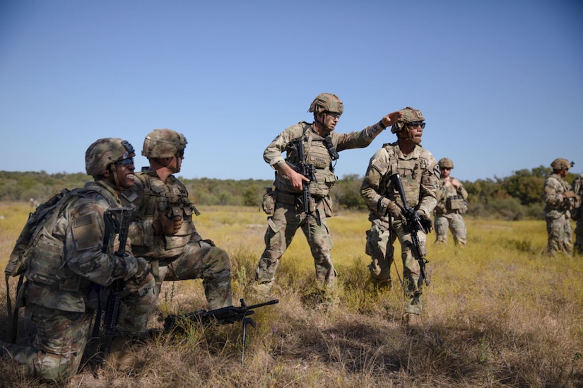 Uniformed soldiers train outdoors.