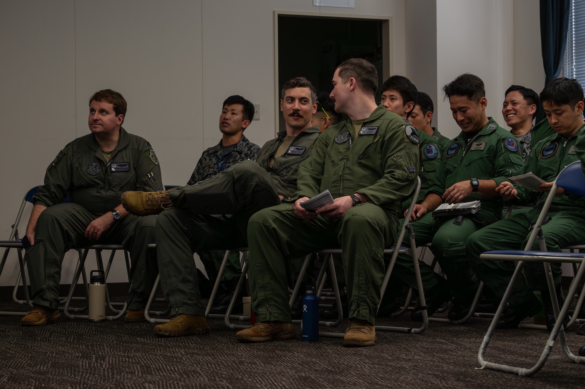 U.S. Air Force and JASDF Airmen discussing details on a briefing