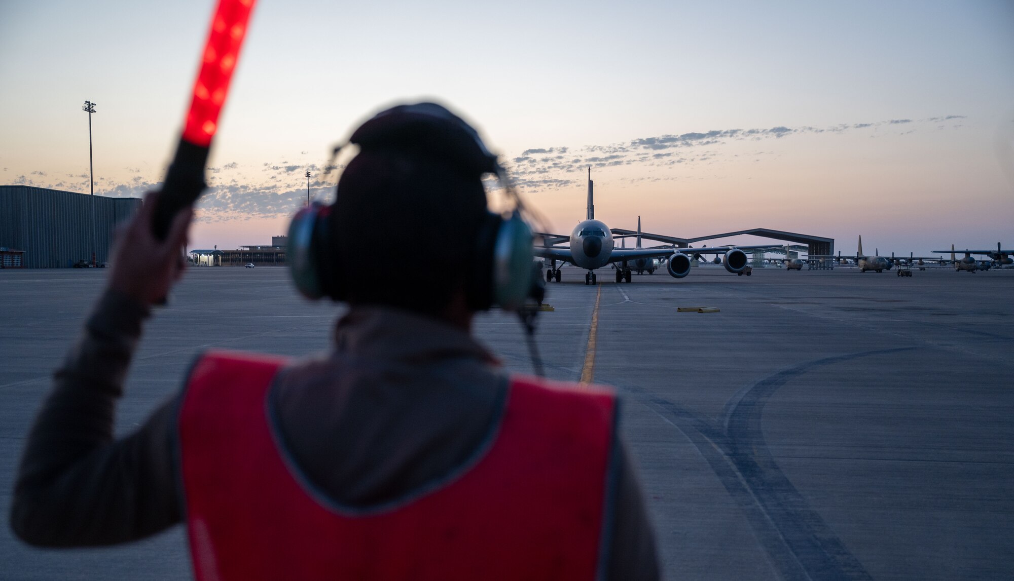 U.S. Air Force Senior Airman Joshua Hardman, 97th Expeditionary Air Refueling Squadron crew chief, marshals a KC-135 Stratotanker to its designated parking spot on the flightline within the U.S. Central Command area of responsibility, Jan. 23, 2025.