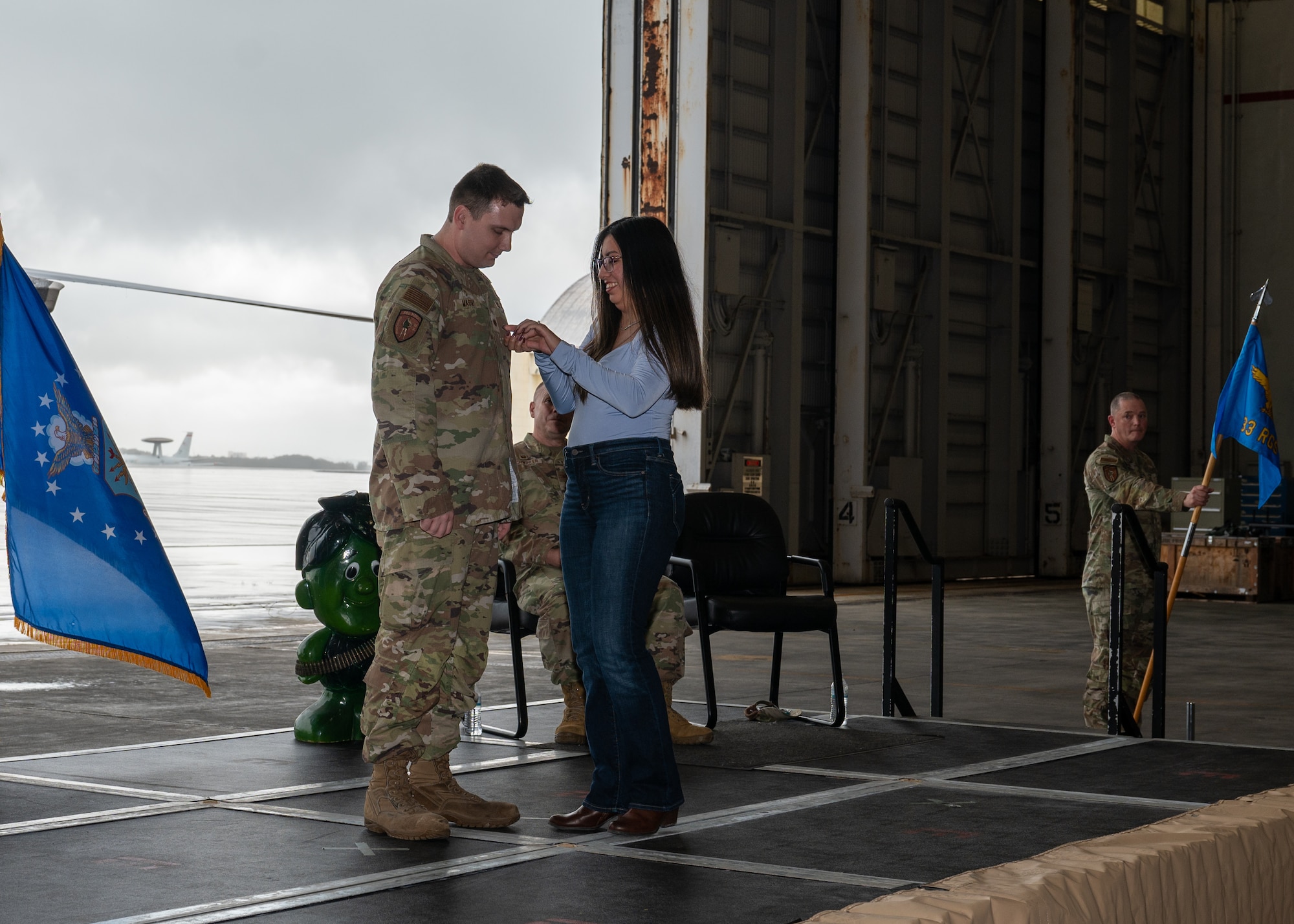 A military service member is getting pinned by his wife.