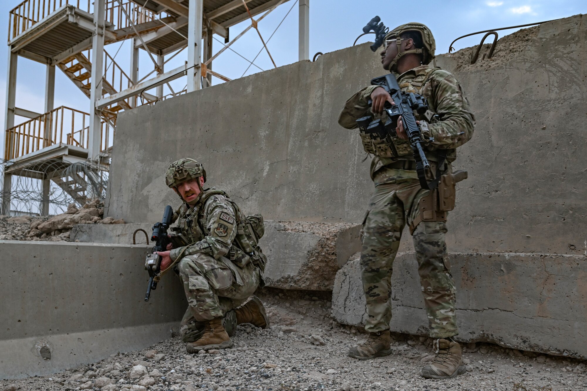 Two men in uniform stand watch during an exercise.