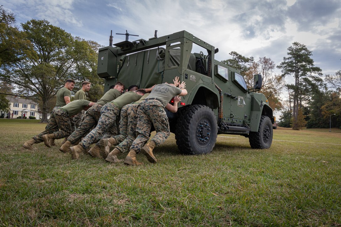 U.S. Marines with the 26th Marine Expeditionary Unit compete in a JLTV push event during a field meet at Camp Lejeune, North Carolina, Nov. 26, 2024. The field meet hosted by the 26th MEU consisted of a modified CFT relay race, tug-of-war, JLTV push, pugil sticks, and a pie-eating contest. (U.S. Marine Corps photo by Lance Cpl. Osmar VasquezHernandez)