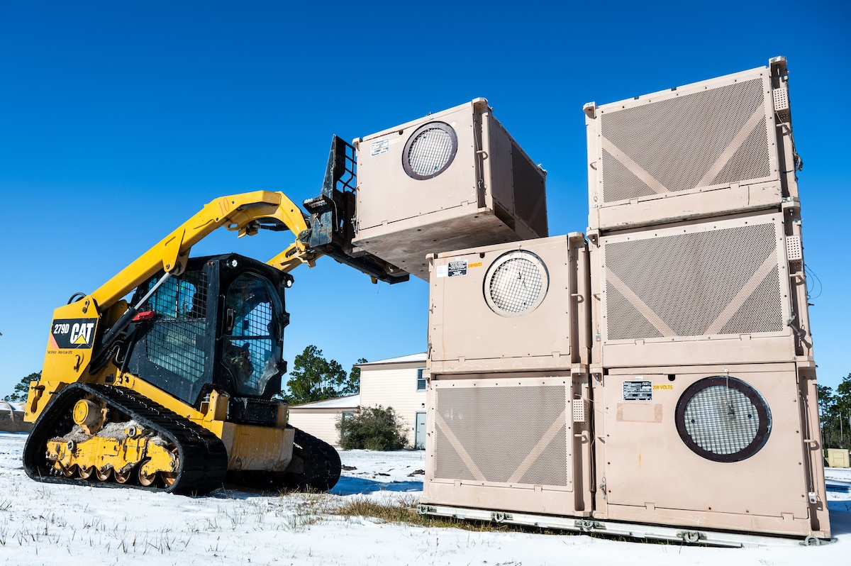A U.S. Airman assigned to the 11th Air Task Force uses a compact track loader vehicle to move a heating, ventilation and air conditioning unit at Tyndall Air Force Base, Florida, Jan. 22, 2025. Civil engineer Airmen maintained the infrastructure and utilities that support combat operations. (U.S. Air Force photo by Senior Airman Jasmyne Bridgers-Matos)